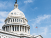 The top of the United States Capitol set against a blue sky with wispy clouds.